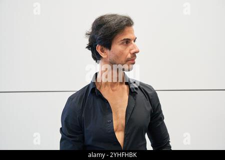 Nahaufnahme eines Indianers in schwarzem Hemd, der ernst mit einem schlichten Hintergrund aussieht. Stockfoto