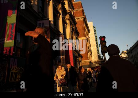 Alltagsleben an einem Wochentag, während die Menschen ihr Leben entlang Piccadilly verfolgen, während die Sonne an einem Winter am späten Nachmittag des 2024. November untergeht, London, Großbritannien Stockfoto