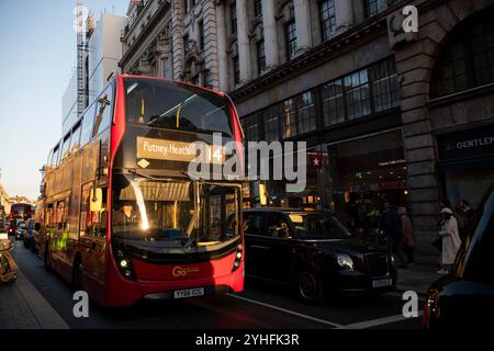 Alltagsleben an einem Wochentag, während die Menschen ihr Leben entlang Piccadilly verfolgen, während die Sonne an einem Winter am späten Nachmittag des 2024. November untergeht, London, Großbritannien Stockfoto