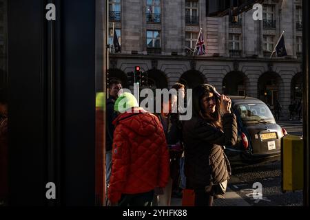 Alltagsleben an einem Wochentag, während die Menschen ihr Leben entlang Piccadilly verfolgen, während die Sonne an einem Winter am späten Nachmittag des 2024. November untergeht, London, Großbritannien Stockfoto