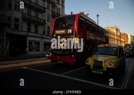 Alltagsleben an einem Wochentag, während die Menschen ihr Leben entlang Piccadilly verfolgen, während die Sonne an einem Winter am späten Nachmittag des 2024. November untergeht, London, Großbritannien Stockfoto