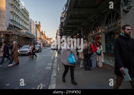 Alltagsleben an einem Wochentag, während die Menschen ihr Leben entlang Piccadilly verfolgen, während die Sonne an einem Winter am späten Nachmittag des 2024. November untergeht, London, Großbritannien Stockfoto