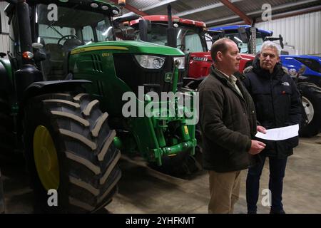 März, England, Großbritannien. November 2024. TIM TAYLOR (links) und der lokale Abgeordnete STEVE BARCLAY sprechen über 20 Fenland-Bauern in einem Traktorschuppen auf der Riverside Farm, wo TAYLOR über die Zusammenarbeit mit anderen Bauern beim Protest in London am 9. November spricht. Der Farmer TIM TAYLOR hat eine Kampagne für Bauern gegründet, die mit der zahnlosen National Farmers Union konkurrieren soll. Seine Gruppe zielt darauf ab, die Landbevölkerung zusammenzubringen und ihre Lebensweise zu bewahren. Sie sprechen von extremen Maßnahmen wie der Blockierung von Straßen und Häfen und der Verweigerung von Waren an Supermärkte nach der Entscheidung der Labour Party, inhe zu wechseln Stockfoto