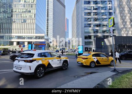 Moskau, Russland - 2. September 2024: Zwei Yandex-Taxis auf einer belebten Straße im Moskauer International Business Center, Russland. Lebhafte Atmosphäre von urba Stockfoto