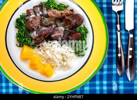 Die beste und traditionellste brasilianische Feijoada der Welt, serviert auf einem grünen und gelben Teller Stockfoto