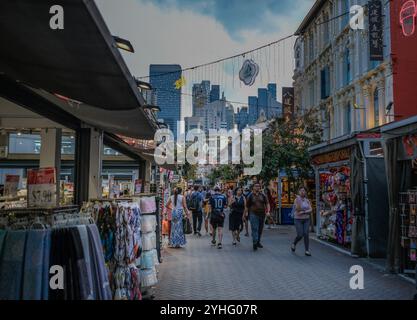 Ein allgemeiner Blick auf den Abendmarkt Chinatown mit Blick auf die Wolkenkratzer in der Ferne, während die Leute die Gegend im Vordergrund erkunden. Stockfoto