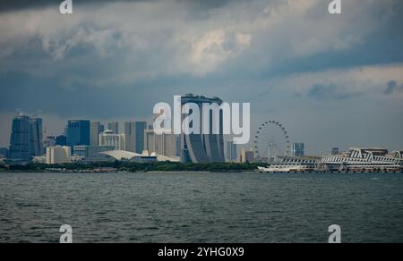 Ein Blick auf die Skyline von Singapur von der Singapore Strait aus mit Marina Bay Sands, Singapore Flyer und City Wolkenkratzern. Stockfoto