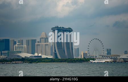 Ein Blick auf die Skyline von Singapur von der Singapore Strait aus mit Marina Bay Sands, Singapore Flyer und City Wolkenkratzern. Stockfoto