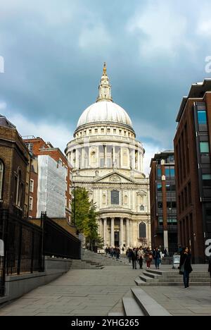 Die prächtige St. Paul’s Cathedral erhebt sich inmitten der modernen Stadtlandschaft, mit einer Menschenmenge, die auf den Stufen vorbeischlendert. Stockfoto