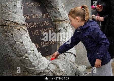 Vancouver, Kanada. November 2024. Ein Mädchen legt einen Mohn auf den Cenotaph während einer Gedenkfeier am Victory Square in Vancouver, British Columbia, Kanada, am 11. November 2024. Quelle: Liang Sen/Xinhua/Alamy Live News Stockfoto