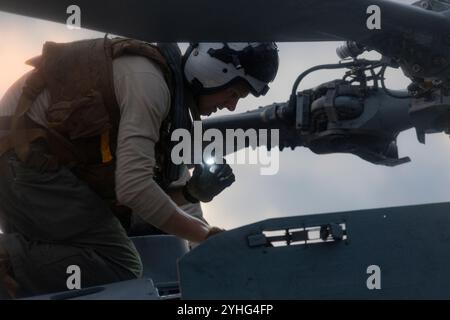 Lt. Daniel Lindauer, der den „Tridents“ der Helicopter Sea Combat Squadron (HSC) 9 zugeordnet ist, führt am 9. November 2024 Vorflugkontrollen an einem MH-60S Seahawk auf dem Flugdeck des weltweit größten Flugzeugträgers USS Gerald R. Ford (CVN 78) durch. Die Gerald R. Ford Carrier Strike Group ist im Atlantik unterwegs und schließt Group Sail ab. Group Sail ist die erste integrierte Schulungsveranstaltung auf See während eines Routine-Schulungszyklus. Es soll die Fähigkeit der Gerald R. Ford CSG, die Fähigkeiten der USS Gerald R. Ford (CVN 78), USS Winston S. Churchill (DDG 81), Stockfoto