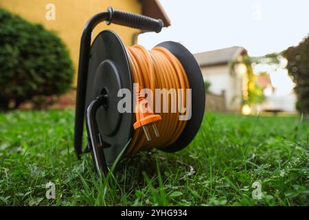 Eine Verlängerungskabelrolle auf grünem Gras im Freien Stockfoto