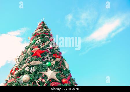 Dekorierter großer Weihnachtsbaum mit farbenfrohen Ornamenten und funkelnden Lichtern Stockfoto