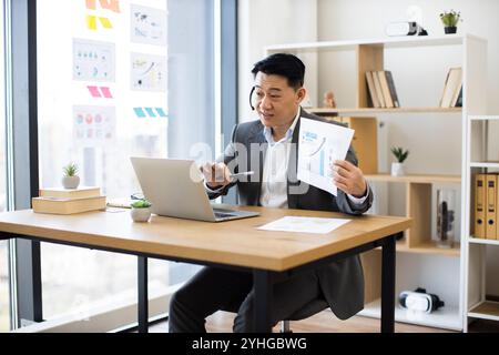 Asiatischer Geschäftsmann mit Headset-Präsentation während eines virtuellen Meetings Stockfoto
