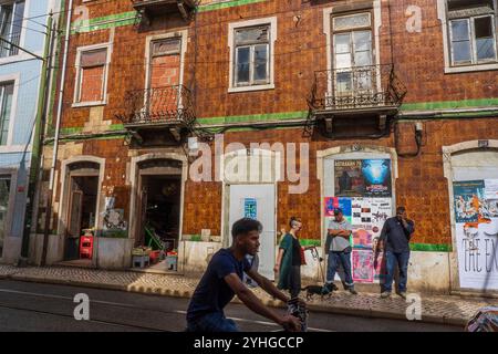 Straßenszene im Stadtteil Baixa-Alfama, farbenfrohe Gebäude, Lebensmittelgeschäfte und Fußgänger. Lissabon, Portugal, Europa Stockfoto