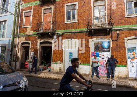 Straßenszene im Stadtteil Baixa-Alfama, farbenfrohe Gebäude, Lebensmittelgeschäfte und Fußgänger. Lissabon, Portugal, Europa Stockfoto