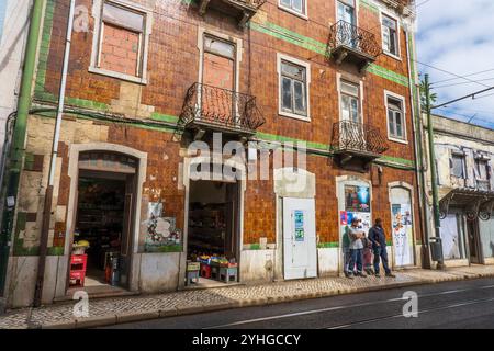 Straßenszene im Stadtteil Baixa-Alfama, farbenfrohe Gebäude, Lebensmittelgeschäfte und Fußgänger. Lissabon, Portugal, Europa Stockfoto