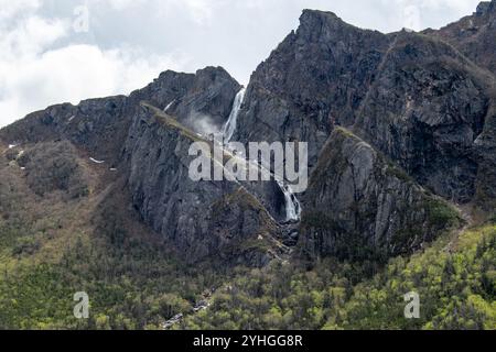 Auf der Spitze einer hohen Klippe in Gros Morne fällt ein kleiner Wasserfall anmutig und unterstreicht die ruhige Schönheit und den zerklüfteten Charme dieser legendären Natio Stockfoto