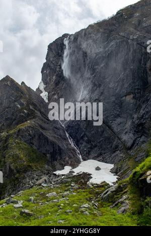 Ein kleiner Wasserfall fließt sanft über den Rand einer Klippe in Gros Morne, seine ruhige Kaskade wird zum Mittelpunkt der zerklüfteten Landschaft, Highlighti Stockfoto