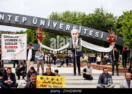 Gaziantep, Turkiye. Mai 2024. Universitätsstudenten in Gaziantep halten eine Solidaritätsdemonstration mit Palästinensern in Gaza ab und verurteilen gleichzeitig die laufende israelische Militäroffensive in der Küstenenklave. Die Teilnehmer schwenkten die palästinensische Flagge, warfen Banner, die westliche Unternehmen, die Israel unterstützen, verurteilten, und zeigten auch Unterstützung für pro-palästinensische Demonstranten auf College-Campus in den Vereinigten Staaten. Umhüllte Babymodelle wurden mit Blumen auf den Boden gelegt, um die große Zahl der in Gaza getöteten Kinder zu betrauern Stockfoto