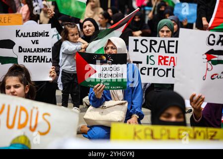 Gaziantep, Turkiye. Mai 2024. Universitätsstudenten in Gaziantep halten eine Solidaritätsdemonstration mit Palästinensern in Gaza ab und verurteilen gleichzeitig die laufende israelische Militäroffensive in der Küstenenklave. Die Teilnehmer schwenkten die palästinensische Flagge, warfen Banner, die westliche Unternehmen, die Israel unterstützen, verurteilten, und zeigten auch Unterstützung für pro-palästinensische Demonstranten auf College-Campus in den Vereinigten Staaten. Umhüllte Babymodelle wurden mit Blumen auf den Boden gelegt, um die große Zahl der in Gaza getöteten Kinder zu betrauern Stockfoto