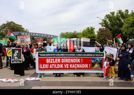 Gaziantep, Turkiye. Mai 2024. Universitätsstudenten in Gaziantep halten eine Solidaritätsdemonstration mit Palästinensern in Gaza ab und verurteilen gleichzeitig die laufende israelische Militäroffensive in der Küstenenklave. Die Teilnehmer schwenkten die palästinensische Flagge, warfen Banner, die westliche Unternehmen, die Israel unterstützen, verurteilten, und zeigten auch Unterstützung für pro-palästinensische Demonstranten auf College-Campus in den Vereinigten Staaten. Umhüllte Babymodelle wurden mit Blumen auf den Boden gelegt, um die große Zahl der in Gaza getöteten Kinder zu betrauern Stockfoto