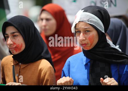 Gaziantep, Turkiye. Mai 2024. Universitätsstudenten in Gaziantep halten eine Solidaritätsdemonstration mit Palästinensern in Gaza ab und verurteilen gleichzeitig die laufende israelische Militäroffensive in der Küstenenklave. Die Teilnehmer schwenkten die palästinensische Flagge, warfen Banner, die westliche Unternehmen, die Israel unterstützen, verurteilten, und zeigten auch Unterstützung für pro-palästinensische Demonstranten auf College-Campus in den Vereinigten Staaten. Umhüllte Babymodelle wurden mit Blumen auf den Boden gelegt, um die große Zahl der in Gaza getöteten Kinder zu betrauern Stockfoto