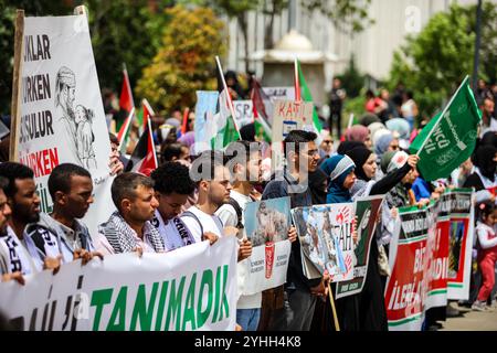 Gaziantep, Turkiye. Mai 2024. Universitätsstudenten in Gaziantep halten eine Solidaritätsdemonstration mit Palästinensern in Gaza ab und verurteilen gleichzeitig die laufende israelische Militäroffensive in der Küstenenklave. Die Teilnehmer schwenkten die palästinensische Flagge, warfen Banner, die westliche Unternehmen, die Israel unterstützen, verurteilten, und zeigten auch Unterstützung für pro-palästinensische Demonstranten auf College-Campus in den Vereinigten Staaten. Umhüllte Babymodelle wurden mit Blumen auf den Boden gelegt, um die große Zahl der in Gaza getöteten Kinder zu betrauern Stockfoto