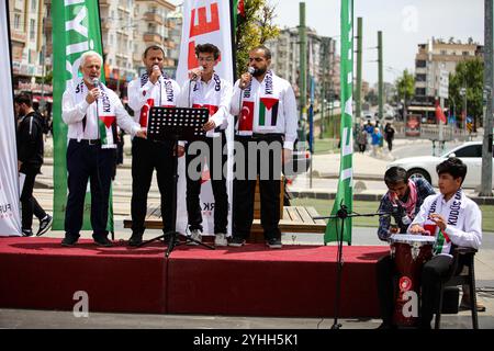 Gaziantep, Turkiye. Mai 2024. Universitätsstudenten in Gaziantep halten eine Solidaritätsdemonstration mit Palästinensern in Gaza ab und verurteilen gleichzeitig die laufende israelische Militäroffensive in der Küstenenklave. Die Teilnehmer schwenkten die palästinensische Flagge, warfen Banner, die westliche Unternehmen, die Israel unterstützen, verurteilten, und zeigten auch Unterstützung für pro-palästinensische Demonstranten auf College-Campus in den Vereinigten Staaten. Umhüllte Babymodelle wurden mit Blumen auf den Boden gelegt, um die große Zahl der in Gaza getöteten Kinder zu betrauern Stockfoto