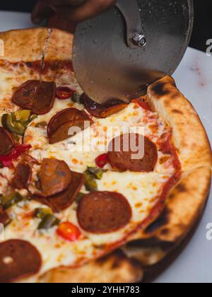 Schneide die Peperoni-Pizza durch Stockfoto