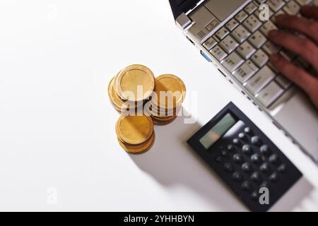 Computer, Taschenrechner und Goldmünzen Stockfoto