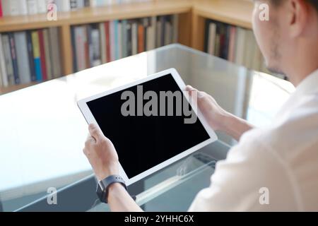 Mann, der ein iPad hält Stockfoto
