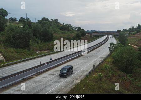 Ein Kleinbus überquert die Mautstraße Balikpapan Samarinda Stockfoto