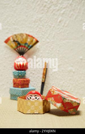 Mini-Daruma-Puppen, eine Kiste aus Chiyogami-Papier und ein Handball Stockfoto