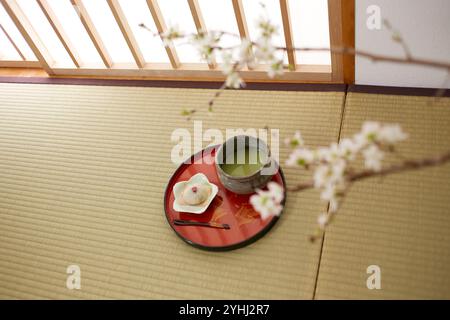 Kirschblütenzweige, Sakura Mochi (Reiskuchen) und grüner Pulvertee Stockfoto