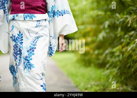 Frau in Yukata, die im japanischen Garten läuft Stockfoto