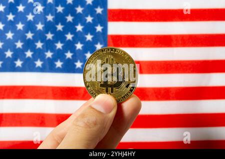 Nahaufnahme von Bitcoin-Münzen und Hintergrund der amerikanischen Flagge. Kryptowährung und Konzept der Vereinigten Staaten von Amerika Stockfoto