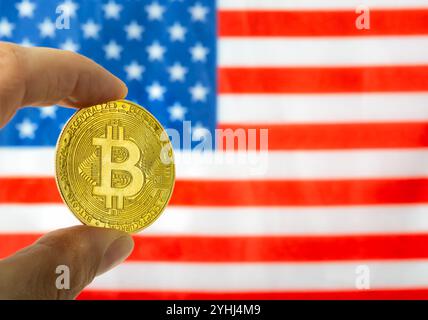 Hand mit Bitcoin und USA Flagge auf dem Hintergrund. Kryptowährung und Konzept der Vereinigten Staaten von Amerika Stockfoto