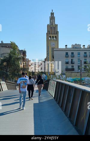 Montcada i Reixac. Spanien - 12. November 2024: Die Fußgängerbrücke in Moncada und Reixac überspannt den Ripoll-Fluss, wobei Fußgänger über den Fluss laufen, was eine Stockfoto