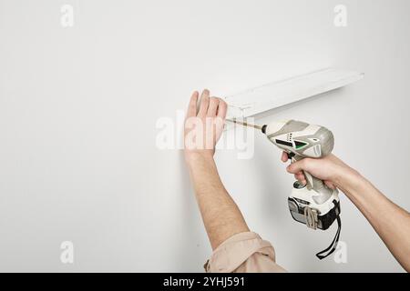 Die Hand des Mannes mit dem Schlagschrauber Stockfoto