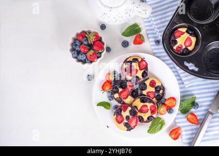 Portionierte gemischte Beerenblätter Pan Baked Pancakes, einfaches Rezept in Muffindosen. Mit frischer Heidelbeere und Erdbeere, Kopierraum Stockfoto