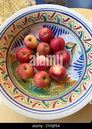 Rote Äpfel in einer farbenfrohen spanischen Schüssel Stockfoto