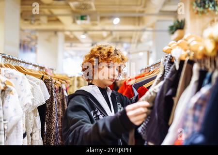 Porträt einer rothaarigen attraktiven jungen Frau, die im Laden Kleidung anprobiert Stockfoto