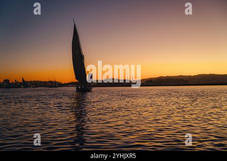 Segelboot auf einem Fluss in Ägypten vor einem Sonnenuntergang Himmel Stockfoto