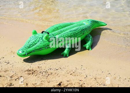 Aufblasbarer Krokodil-Strand, aufblasbares Krokodil-Strandspielzeug, verspielte Strandmomente, lustige Strandszenen, aufblasbares Spielzeug am Strand, Konzept Sommer Stockfoto