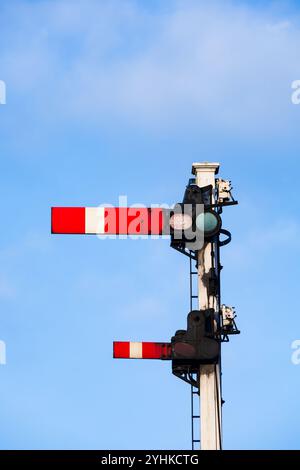 Britische Semaphore-Eisenbahnsignale im unteren Quadranten gegen blauen Himmel. Bahnhof Grosmont, NYMR. North Yorkshire, England Stockfoto