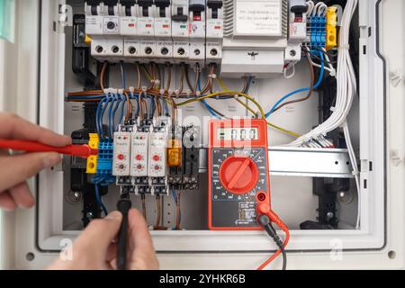 Techniker, der die elektrische Leiterplatte mit Multimeter prüft Stockfoto