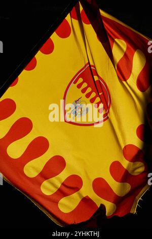 Flagge der contrada (traditionelles Viertel) von Santo Agnolo in Volterra, Toskana, Italien. Diese moderne Version der Flagge enthält das abnehmende Mond-Emblem der contrada und eine Darstellung des Heiligen Erzengels Michael. Stockfoto