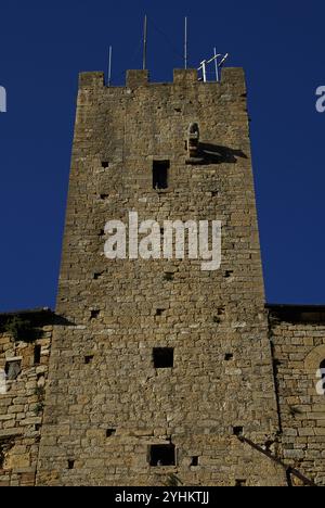 Der Torre del Porcellino (Turm des Ferkels) in Volterra, Toskana, Italien, benannt nach einer stark verwitterten Steinschnitzerei eines Wildschweins, die auf diesem Bild oben und rechts vom oberen Fenster zu sehen ist. Der Torre del Porcelino erhebt sich vom Palazzo Pretorio auf der Piazza dei priori und gilt als einer der ältesten mittelalterlichen Türme Volterras. Stockfoto