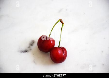 Kirsche auf weißem Hintergrund, frische Kirsche, rote Kirsche, Kirsche Nahaufnahme, reife Kirsche, Kirschfrucht, Kirschdetail, einzelne Kirsche, zwei Kirschen Stockfoto